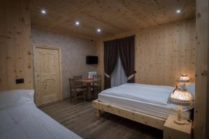 a bedroom with two beds and a desk and a table at Chalet La Rugiada in Valdisotto