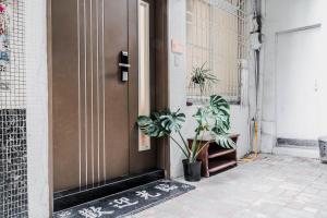 a brown door with plants on the side of a building at MH Alley in Tainan