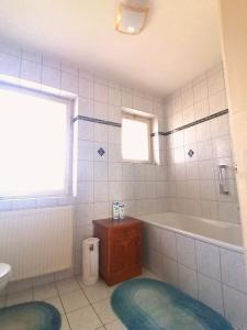 a bathroom with a tub and a toilet and a sink at Dimai House 1970s in Hohenems