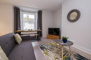 uma sala de estar com um sofá e uma televisão em Beautiful Central Apartment em Brighton & Hove