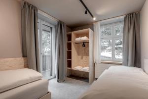 a bedroom with two beds and a window at Belmont- Apartment Haus in Arosa