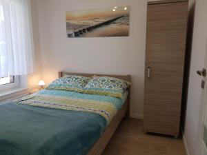 Un dormitorio con una cama con un cuadro en la pared. en Fala Baltyku Apartament, en Ustronie Morskie 20 fotos más