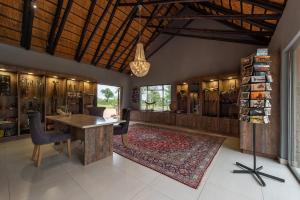 Habitación grande con mesa y alfombra. en Nkorho Bush Lodge, en Reserva de caza Sabi Sand