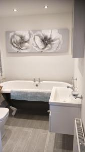 a bathroom with a tub and a toilet and a sink at Mallard Cottage Guest House in Aylesford