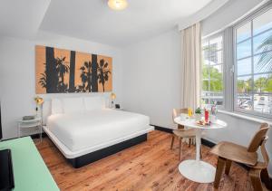 a room with a bed, table and a painting on the wall at AxelBeach Miami South Beach - Adults Only in Miami Beach
