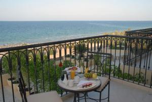 a table on a balcony with a view of the ocean at Mövenpick Resort & Marine Spa Sousse in Sousse