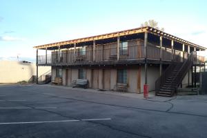 an apartment building with a balcony and a parking lot at Tombstone Motel in Tombstone