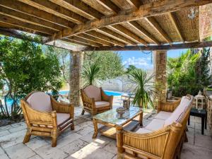 eine Außenterrasse mit Stühlen und einem Tisch in der Unterkunft Apartment in Murter with Pool and Sea Views in Murter