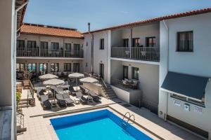 widok na hotel z basenem i meblami ogrodowymi w obiekcie Kiwi Apartments w Kato Daratso
