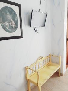 un banco de madera en una habitación con una foto en la pared en Hospedería El Caravansar, en Frigiliana