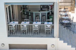 a balcony with four stools and a bar at Kiwi Apartments in Kato Daratso