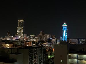 a lit up tower in a city at night at APA Hotel Nambaminami Ebisucho Eki Shinsekai in Osaka