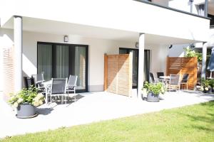 patio domu z krzesłami i trawą w obiekcie Appartements Freiraum w Schladming