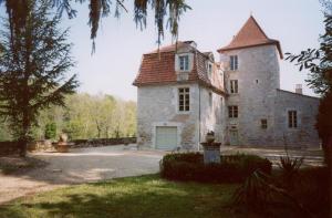 a large stone building with a tower on top of it at Le Manoir du Port in Grézels