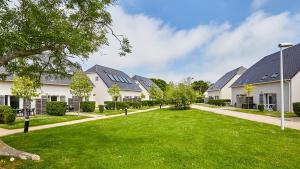 uma fila de casas com um relvado verde em Vacancéole - Le Domaine de la Corniche - Deauville Sud em Auberville