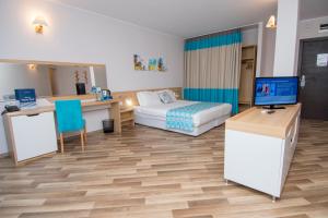 a hotel room with a bed and a desk at Nevis Resort & Aqua Park - All Inclusive in Sunny Beach +140 photos