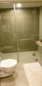 a bathroom with a toilet and a glass shower at Eternal wave by HappyInch in Calangute