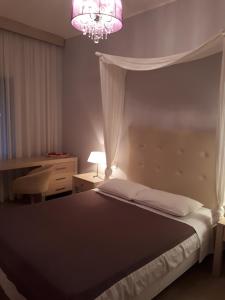 a bedroom with a bed and a chandelier at Viena Rooms & Apartments in Palaiochóra