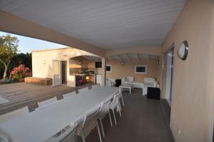 une pièce avec une longue table et des chaises blanches dans l'établissement Villa Poggio Rosso - Pool-House & Piscine chauffée, à Sainte-Lucie de Porto-Vecchio