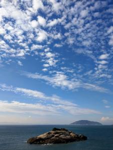 a large rock in the ocean under a cloudy sky at Chinbe D.S House 2 in Beigan