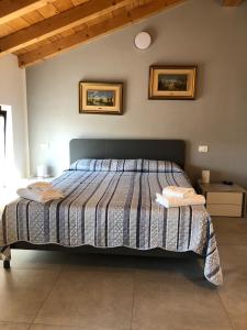 a bed in a bedroom with two pictures on the wall at La casa della Ada in Castelnuovo del Garda