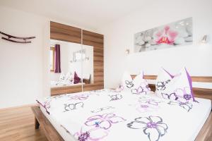 ein Schlafzimmer mit einem Bett mit rosa Blumen drauf in der Unterkunft Apartment Sunshine in Nauders