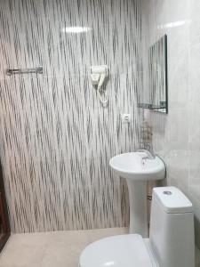 La salle de bains est pourvue de toilettes blanches et d'un lavabo. dans l'établissement Rio cottage apartment, à Ureki