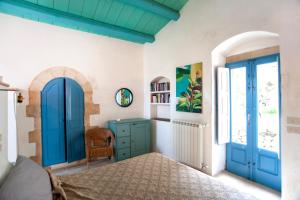 a bedroom with blue doors and a bed at IL CORVO DI PIETRA in Scicli