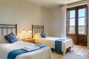 1 dormitorio con 2 camas y ventana con vistas en Casa Sarasa, en Berdún