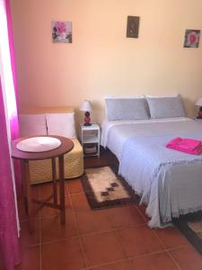 a bedroom with two beds and a small table at Casa Da Estela in Carrapateira