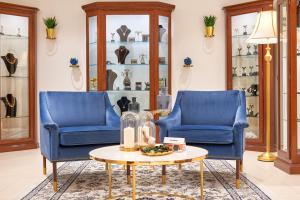 a living room with two blue chairs and a table at Hotel Cvita in Split