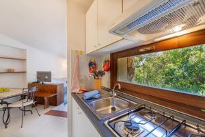 een keuken met een wastafel en een aanrecht met een raam bij Ambra White in Li Valcaggi