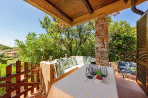 een terras met een tafel en stoelen op een dek bij Ambra White in Li Valcaggi