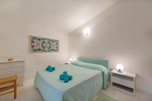 een slaapkamer met een bed met blauwe bogen erop bij Ambra White in Li Valcaggi +26 foto's