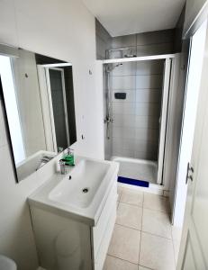 biała łazienka z umywalką i prysznicem w obiekcie Marine Lovers - Jacuzzi Fuerteventura w mieście Gran Tarajal