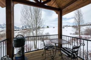 a porch with a table and chairs and a snow covered field at Powder Mountain Town Home With Movie Theater Room C103 in Eden
