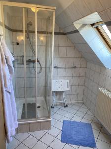 a attic bathroom with a shower and a sink at Appartement Vermietung Jensen in Morsum