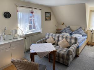 a living room with a couch and a bed and a table at Appartement Vermietung Jensen in Morsum