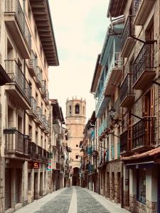 an empty street with a clock tower in the distance at Aldamar apartamentua PARKING INCLUIDO in Getaria