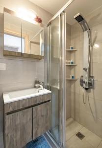 La salle de bains est pourvue d'une douche et d'un lavabo. dans l'établissement Downtown City Apartment, à Thessalonique