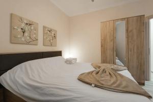 - une chambre avec un lit blanc et une armoire en bois dans l'établissement Downtown City Apartment, à Thessalonique