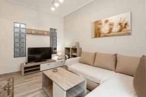 - un salon avec un canapé et une télévision dans l'établissement Downtown City Apartment, à Thessalonique