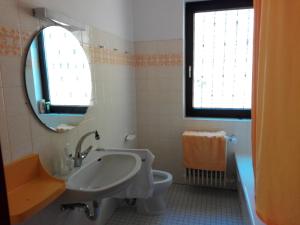 a bathroom with a sink and a toilet and a mirror at Maison au soleil in Egloffstein