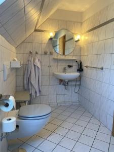 a bathroom with a toilet and a sink at Appartement Vermietung Jensen in Morsum