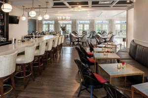un restaurant avec des tables et des chaises ainsi qu'un bar dans l'établissement Mirbeau Inn & Spa, Rhinebeck, à Rhinebeck