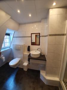 a white bathroom with a sink and a toilet at Hotel Restaurant Zum Holländer Hof in Bad Arolsen