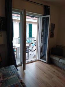 ein Wohnzimmer mit einer Tür, die auf einen Balkon führt in der Unterkunft Azzurra casa vacanza in Ventimiglia