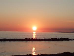 einen Sonnenuntergang über dem Meer mit Sonnenuntergang in der Unterkunft Azzurra casa vacanza in Ventimiglia