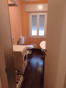a bathroom with a toilet and a sink and a window at Azzurra casa vacanza in Ventimiglia