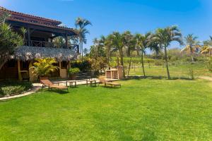 a park with benches and a building with palm trees at Villa Ibiscus in Las Galeras